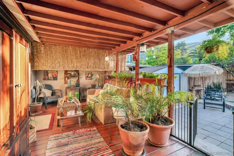 a view of patio with a table and chairs and a barbeque