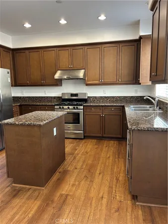 a kitchen with stainless steel appliances granite countertop a stove a sink and a granite counter top