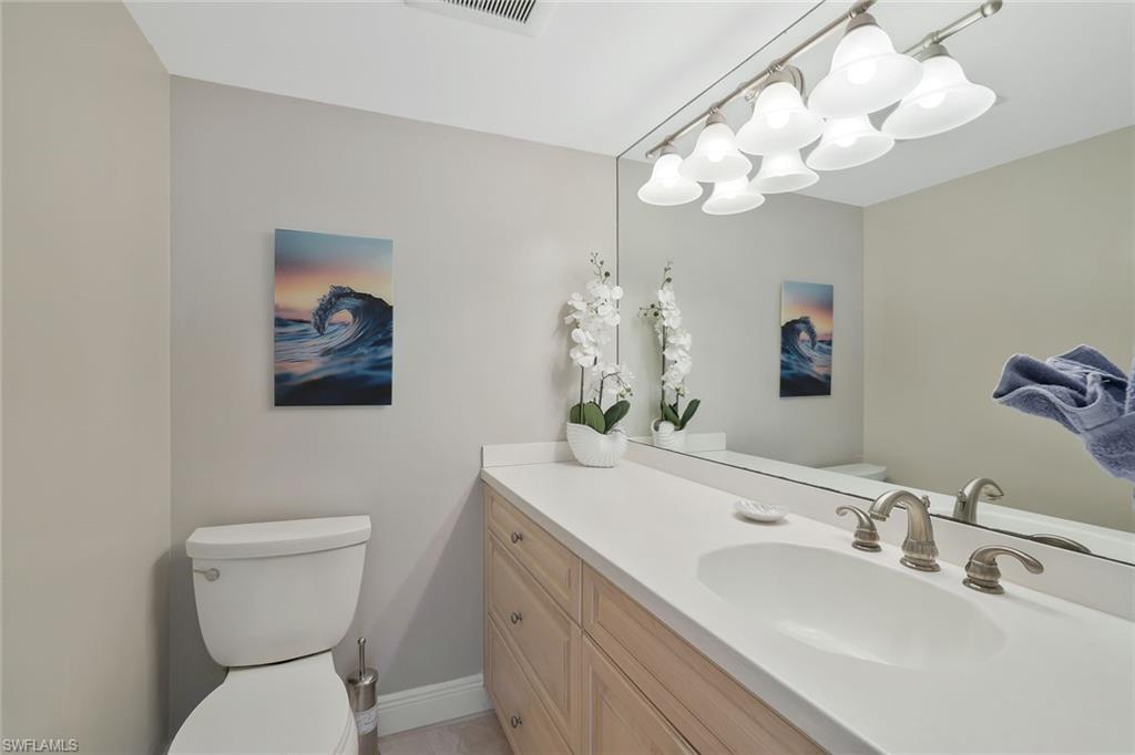 730 South Collier Boulevard, Unit 1303 Marco Island, FL 34145 - Photo 19 of 26 a bathroom with a toilet sink and mirror