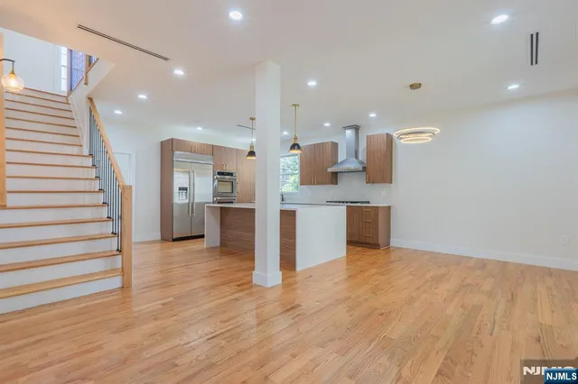 a view of kitchen with kitchen island stainless steel appliances cabinets and wooden floor