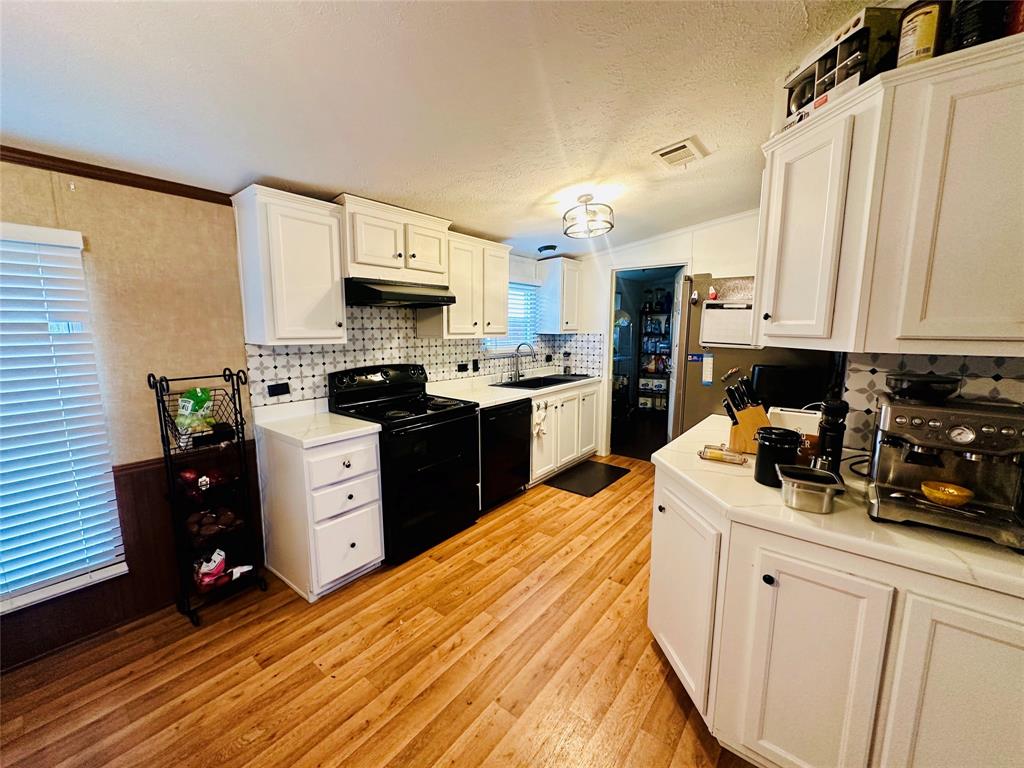 219 County Road 2723 Decatur, TX 76234 - Photo 16 of 26 a kitchen with stainless steel appliances kitchen island granite countertop a refrigerator a stove top oven a sink and dishwasher with wooden floor