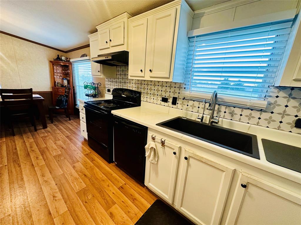 219 County Road 2723 Decatur, TX 76234 - Photo 17 of 26 a kitchen with granite countertop a sink a stove and cabinets