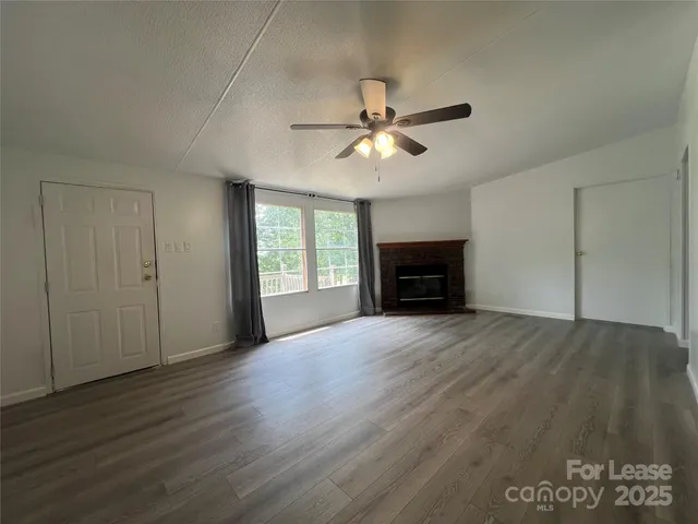 a view of empty room with wooden floor and fireplace