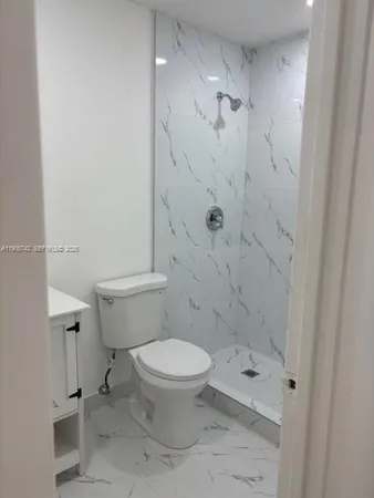 a white toilet sitting next to a bathroom sink