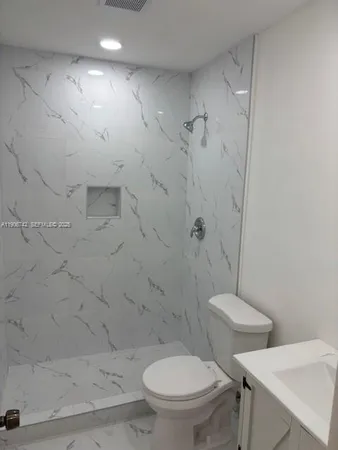 a white toilet sitting next to a bath tub and a shower