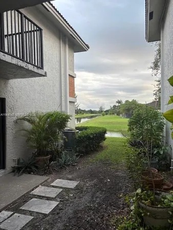 an aerial view of a house with a yard and lake view in background
