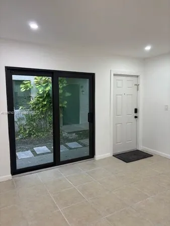 an empty room with large window and doors