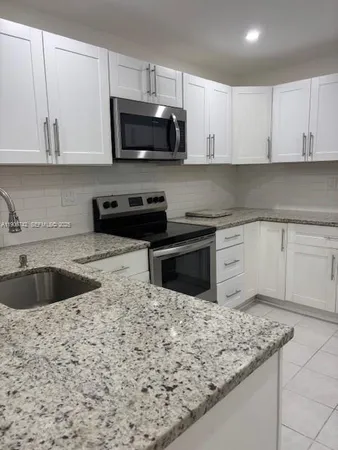 a kitchen with stainless steel appliances granite countertop a sink and a stove