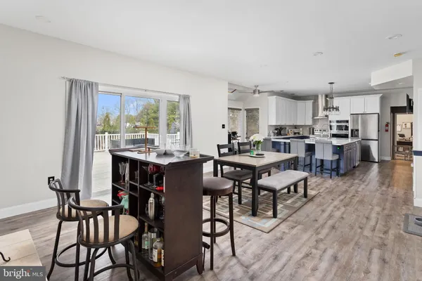 a living room with stainless steel appliances kitchen island granite countertop furniture and wooden floor