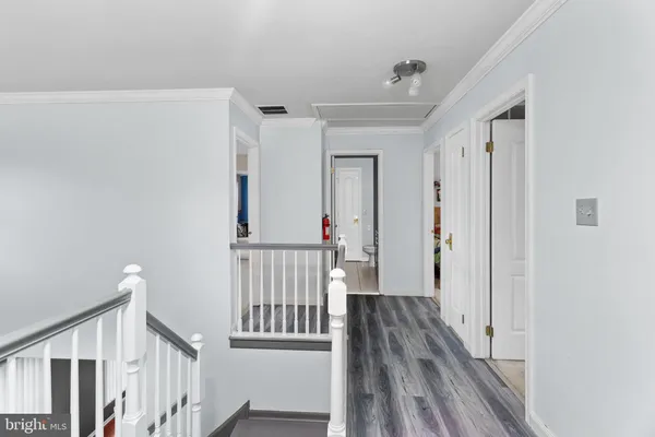 a view of a hallway with wooden floor and staircase