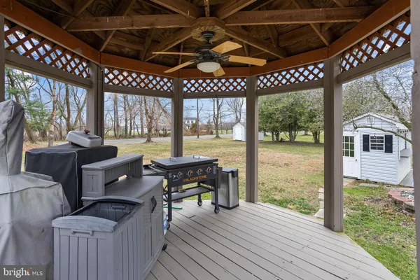 a view of a patio with couches chairs and wooden floor