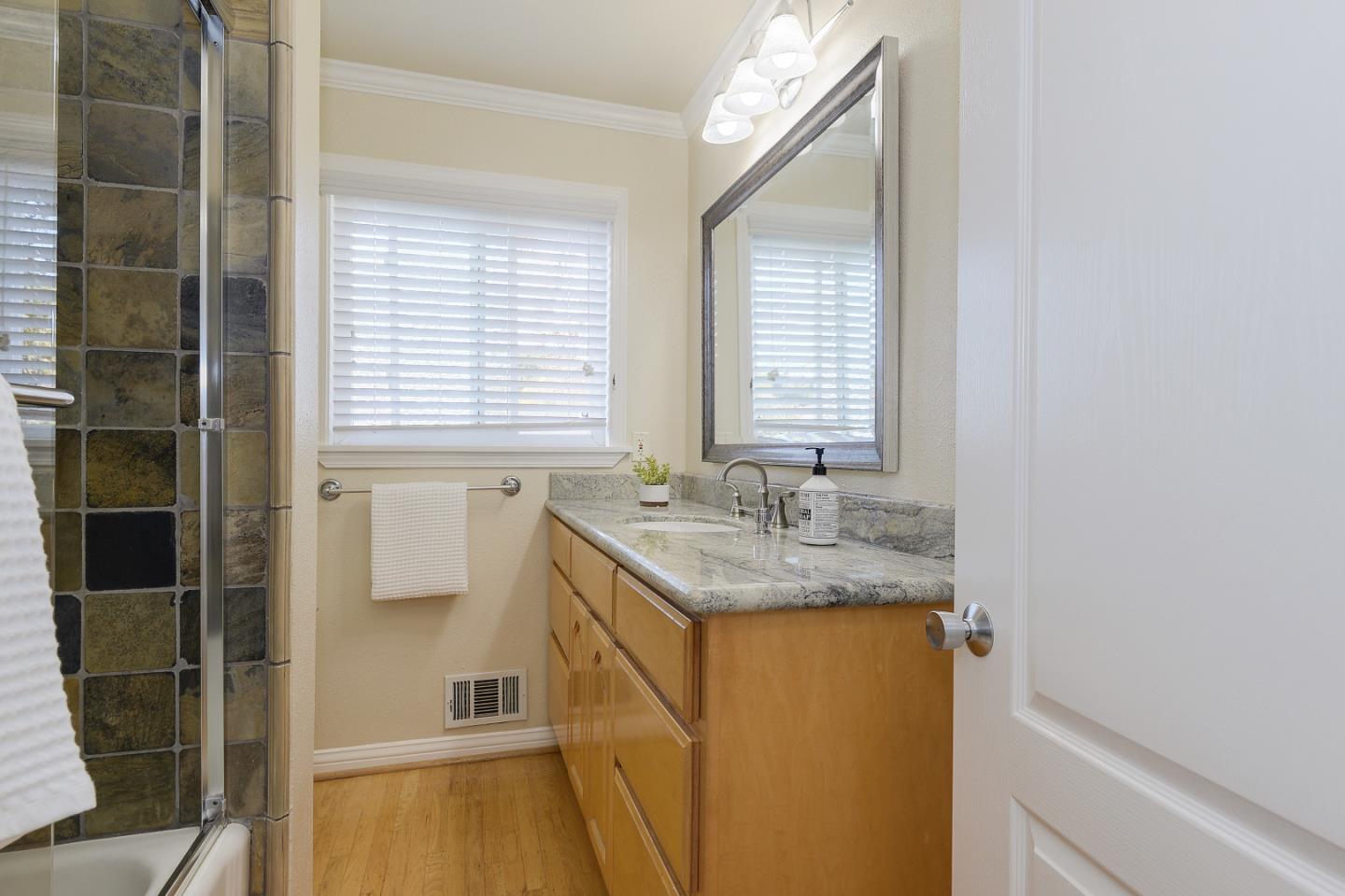 10510 Creston Drive Los Altos, CA 94024 - Photo 18 of 25 a bathroom with a granite countertop sink a mirror and a shower