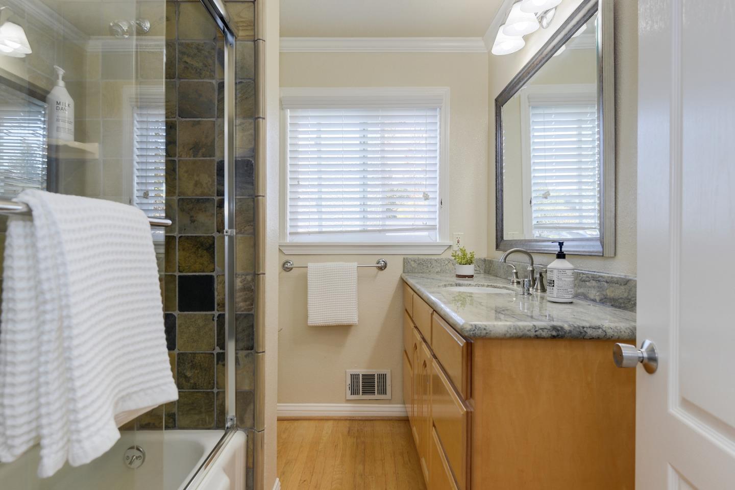 10510 Creston Drive Los Altos, CA 94024 - Photo 19 of 25 a bathroom with a granite countertop sink and a mirror