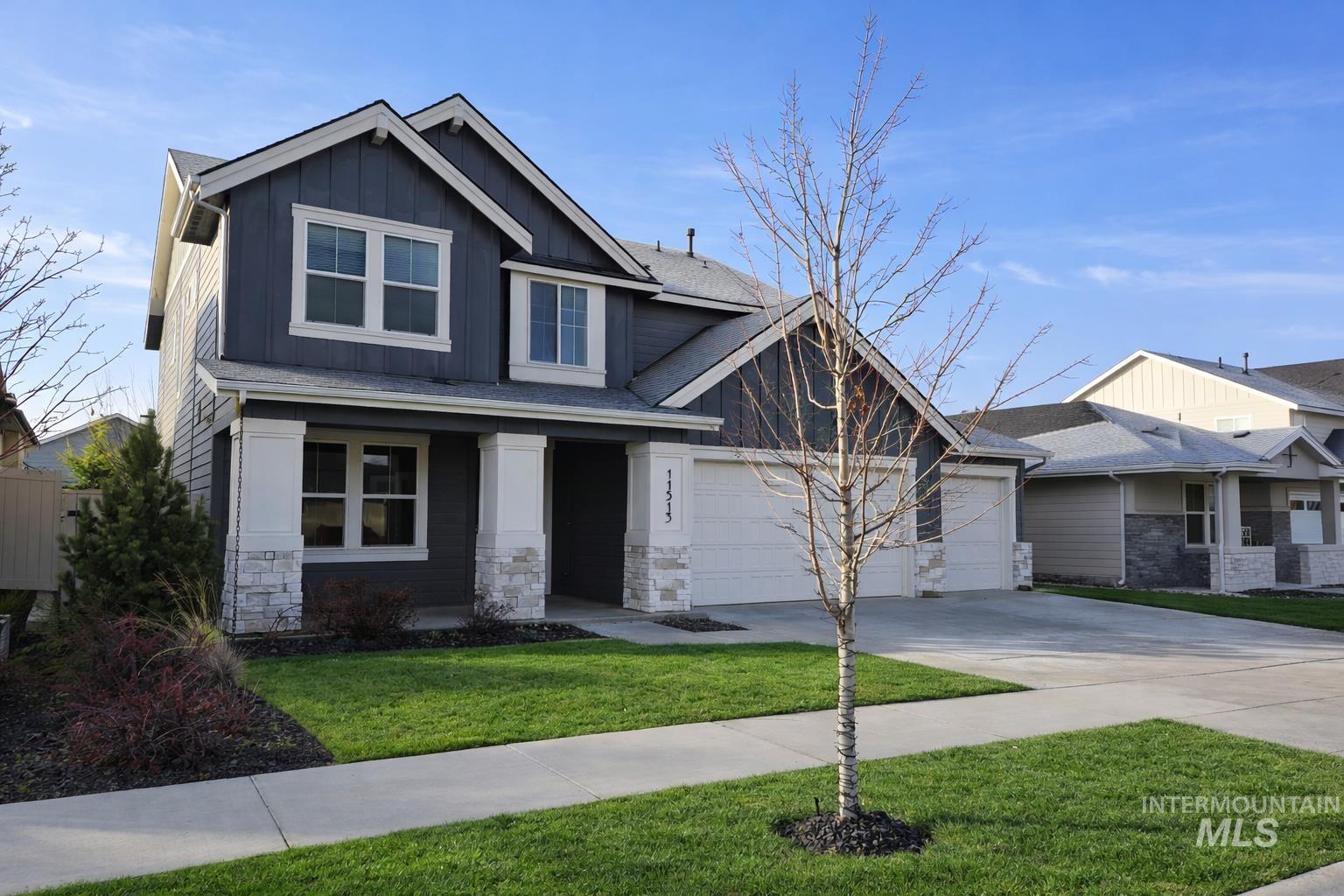 Craftsman house featuring a front yard, concrete driveway, board and batten siding, stone siding, and covered porch