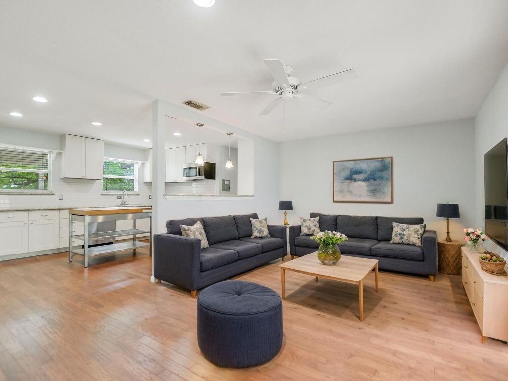 a living room with furniture and a view of kitchen