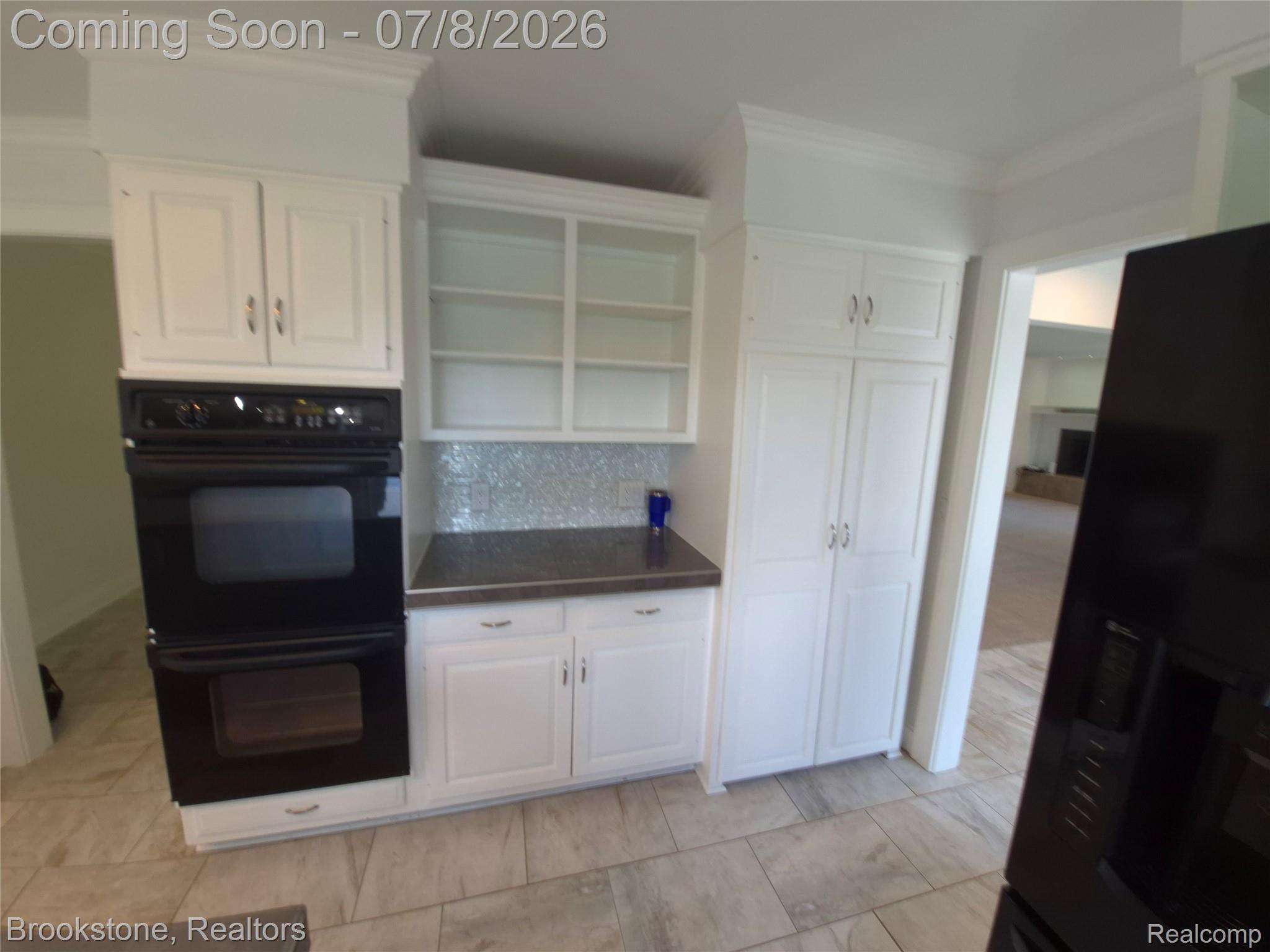 4140 South Henderson Road Davison, MI 48423 - Photo 24 of 98 Kitchen featuring white cabinetry, built-in double ovens, dark countertops, a tiled backsplash, and light tile flooring