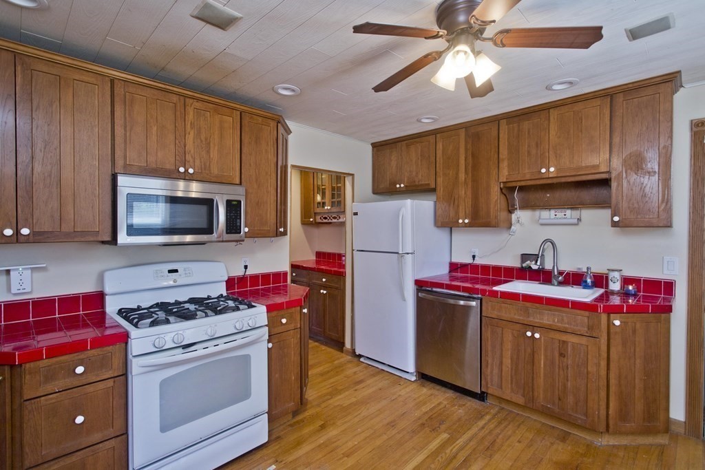 4 Laurel Street Chicopee, MA 01020 - Photo 3 of 35 a kitchen with stainless steel appliances wooden cabinets and a stove top oven