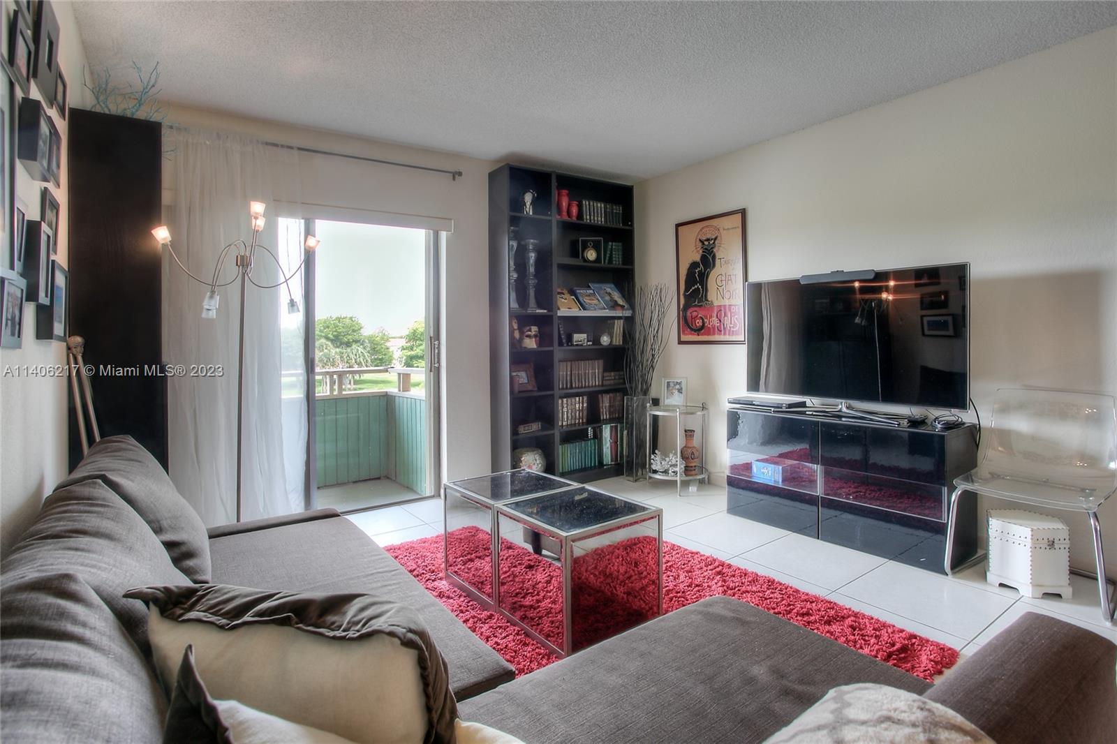 17530 Northwest 68th Avenue, Unit C3010 Hialeah, FL 33015 - Photo 4 of 15 a living room with furniture and a flat screen tv