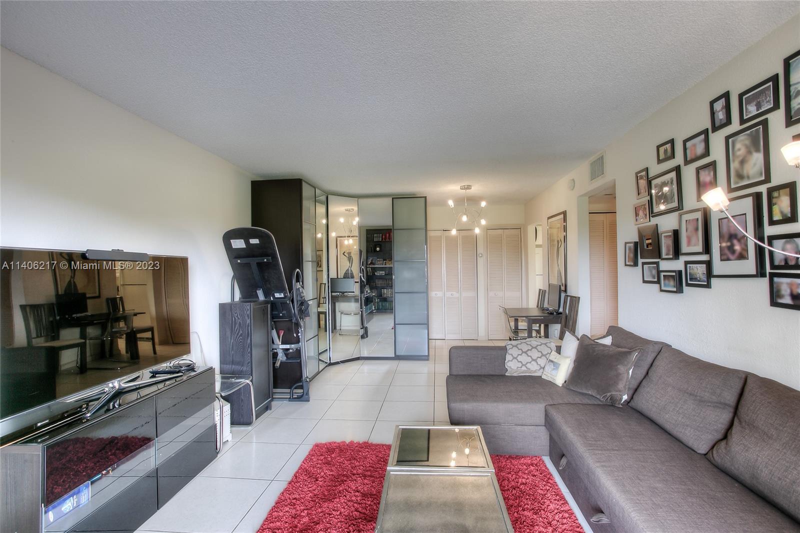 17530 Northwest 68th Avenue, Unit C3010 Hialeah, FL 33015 - Photo 5 of 15 a living room with furniture and a flat screen tv