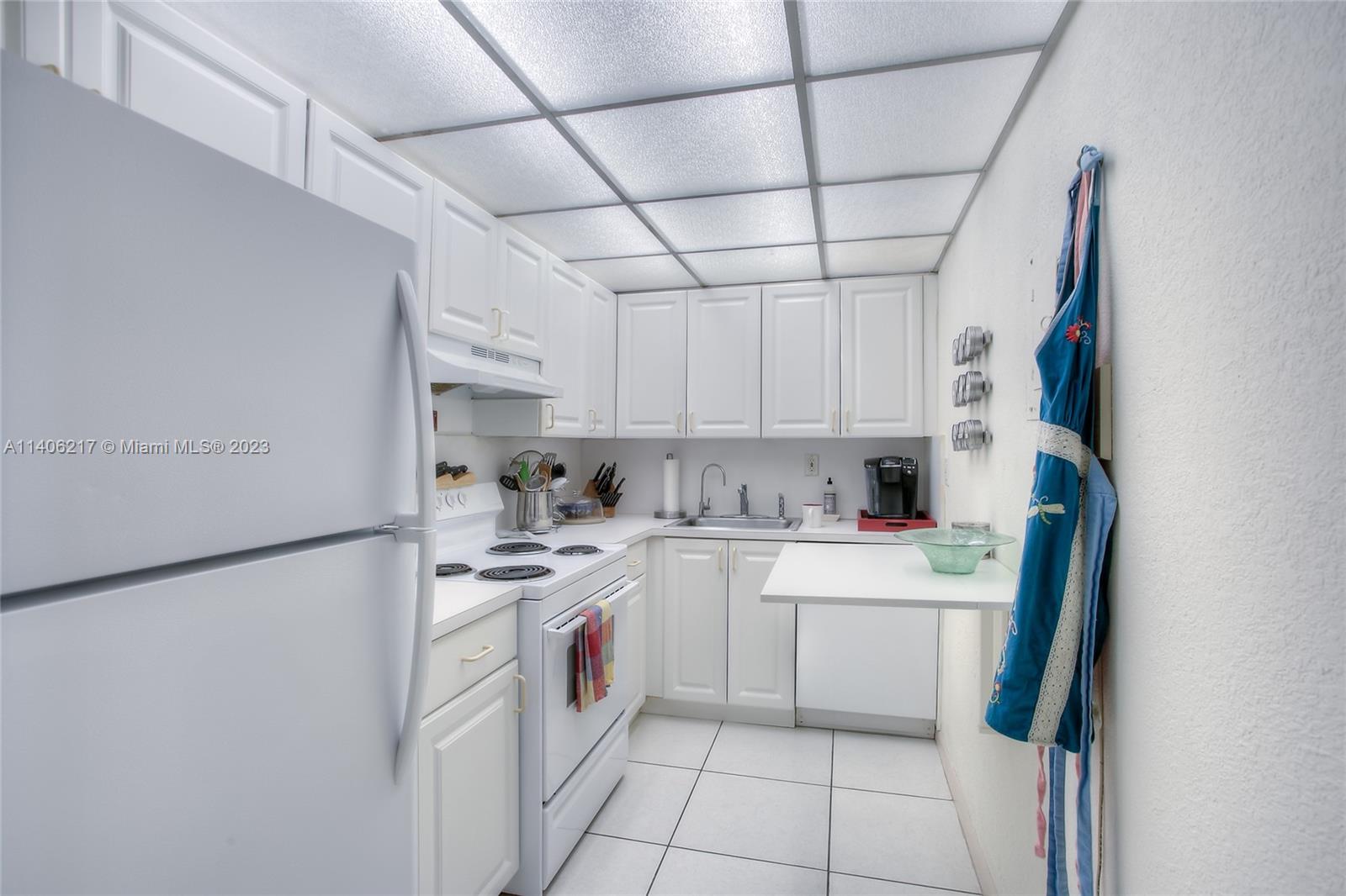 17530 Northwest 68th Avenue, Unit C3010 Hialeah, FL 33015 - Photo 7 of 15 a kitchen with a sink a refrigerator and cabinets