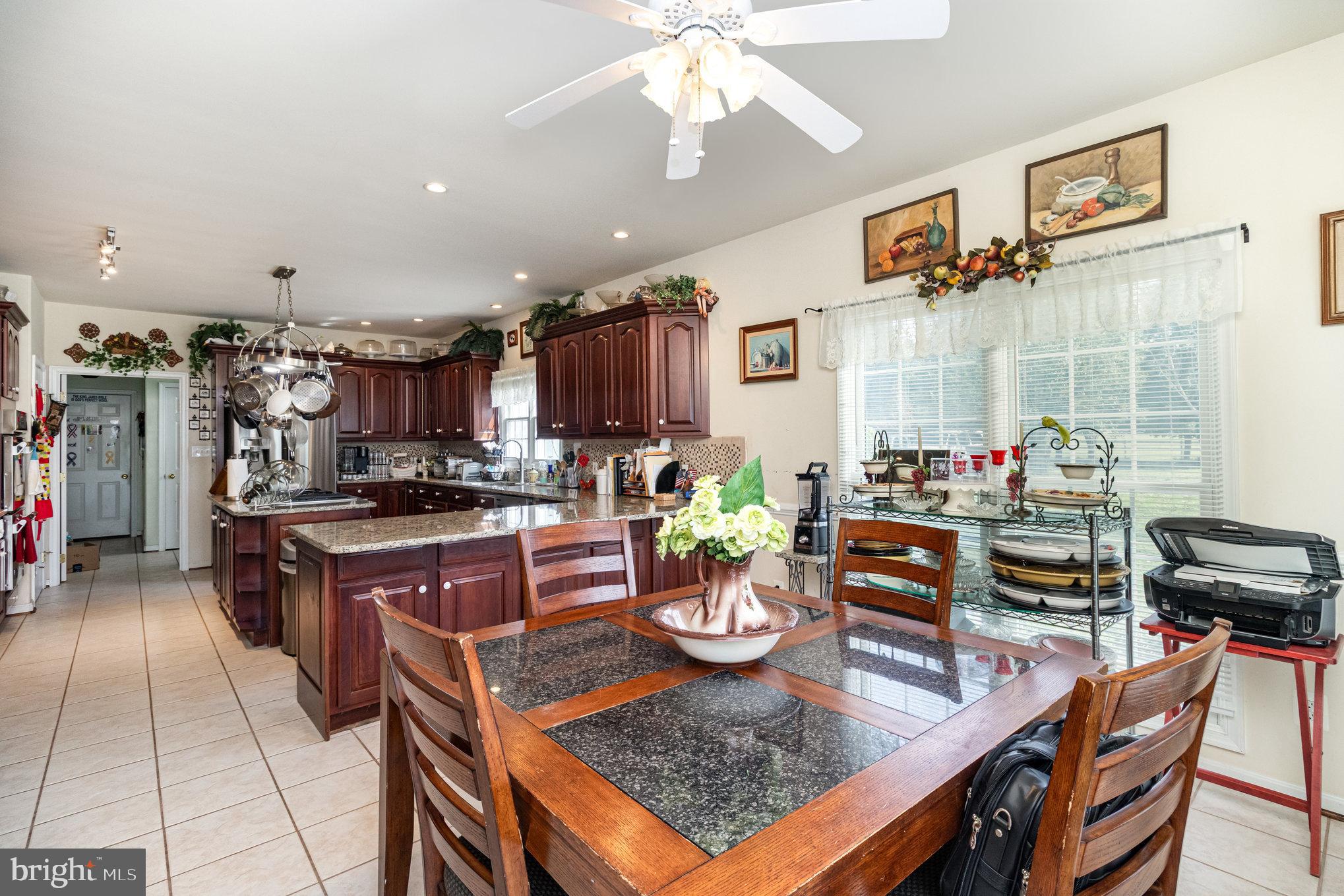 13467 Ellis Way King George, VA 22485 - Photo 15 of 81 a kitchen with stainless steel appliances granite countertop a stove top oven a dining table and chairs with white cabinets
