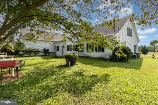 a front view of a house with a garden and trees