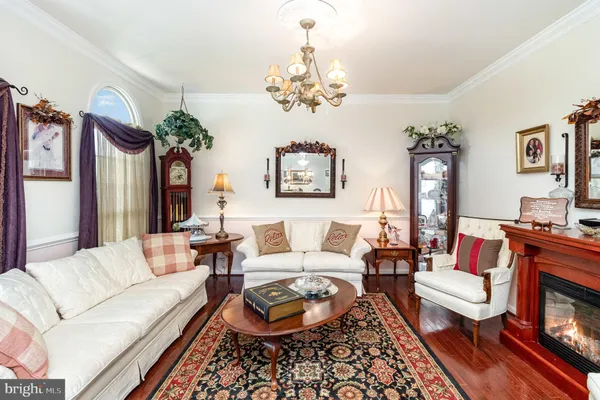 a living room with furniture a chandelier and a fireplace