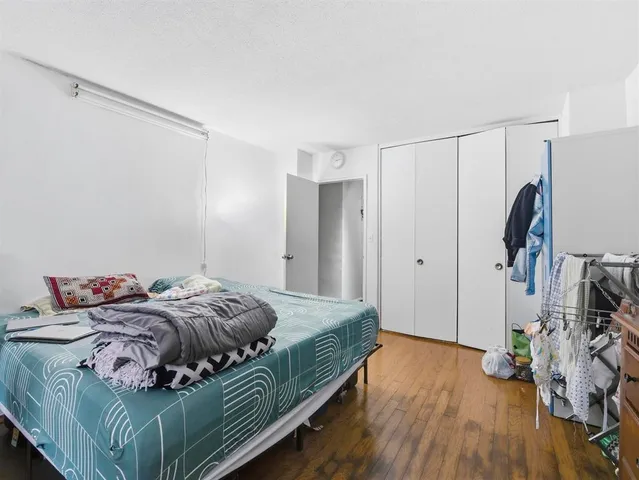 a bedroom with a bed and a flat tv screen on the dresser
