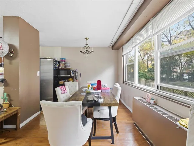 a dining room with furniture a chandelier and wooden floor