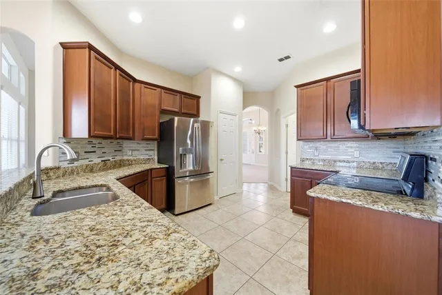 an empty room with chandelier and windows