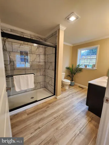 a bathroom with a granite countertop sink a mirror and shower