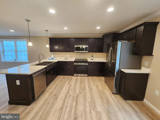 a large kitchen with stainless steel appliances kitchen island granite countertop a sink a stove and a refrigerator