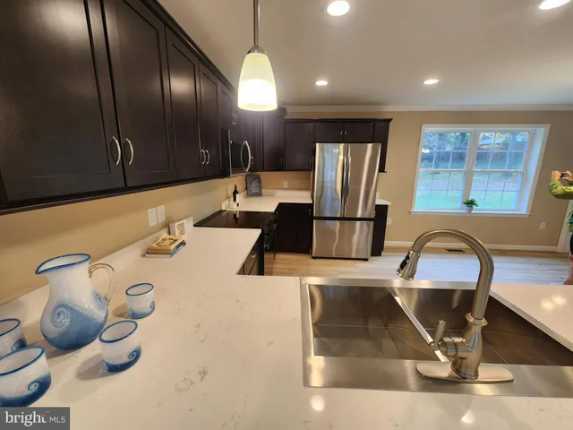 a kitchen with stainless steel appliances granite countertop a sink refrigerator and cabinets