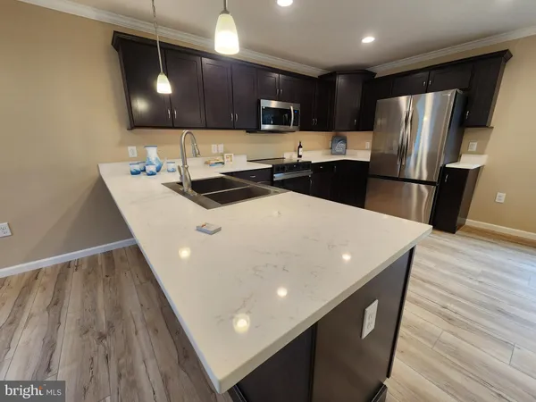 a kitchen with stainless steel appliances a microwave a sink a stove a refrigerator and cabinets