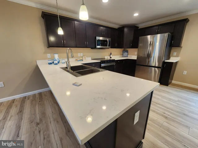 a kitchen with stainless steel appliances a microwave a sink a stove a refrigerator and cabinets