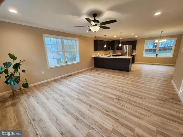 a view of a living room and kitchen with hardwood floor