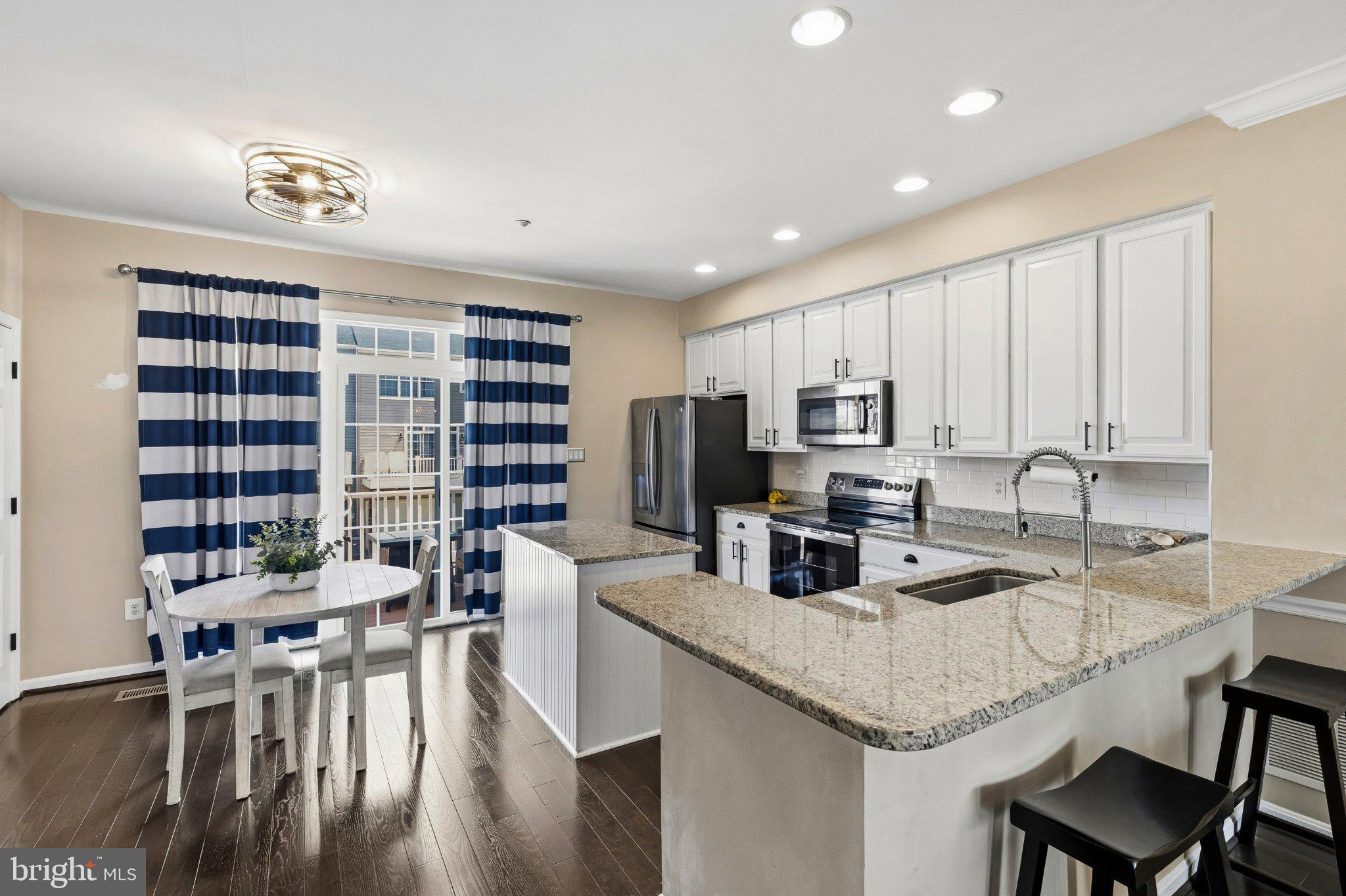 2668 Merlin Court Odenton, MD 21113 - Photo 7 of 42 a kitchen with a dining table chairs and refrigerator