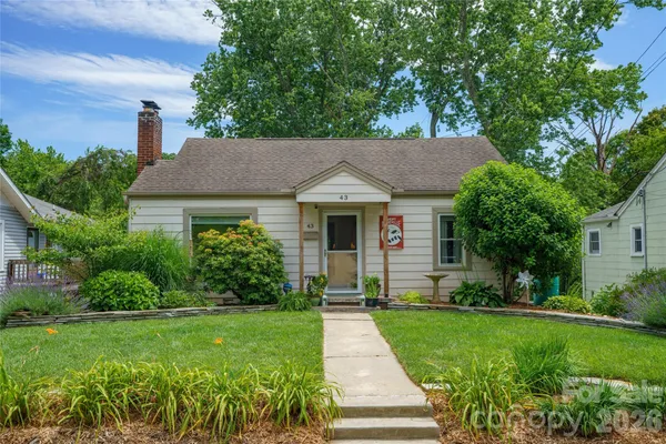 a front view of a house with a yard and trees