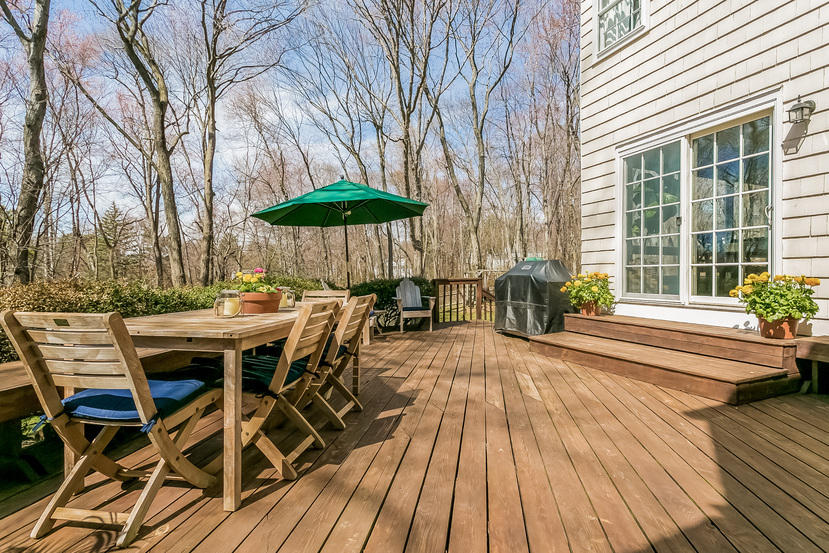 17 Miller Road Darien, CT 06820 - Photo 18 of 21 a view of a patio with table and chairs under an umbrella with wooden floor and fence