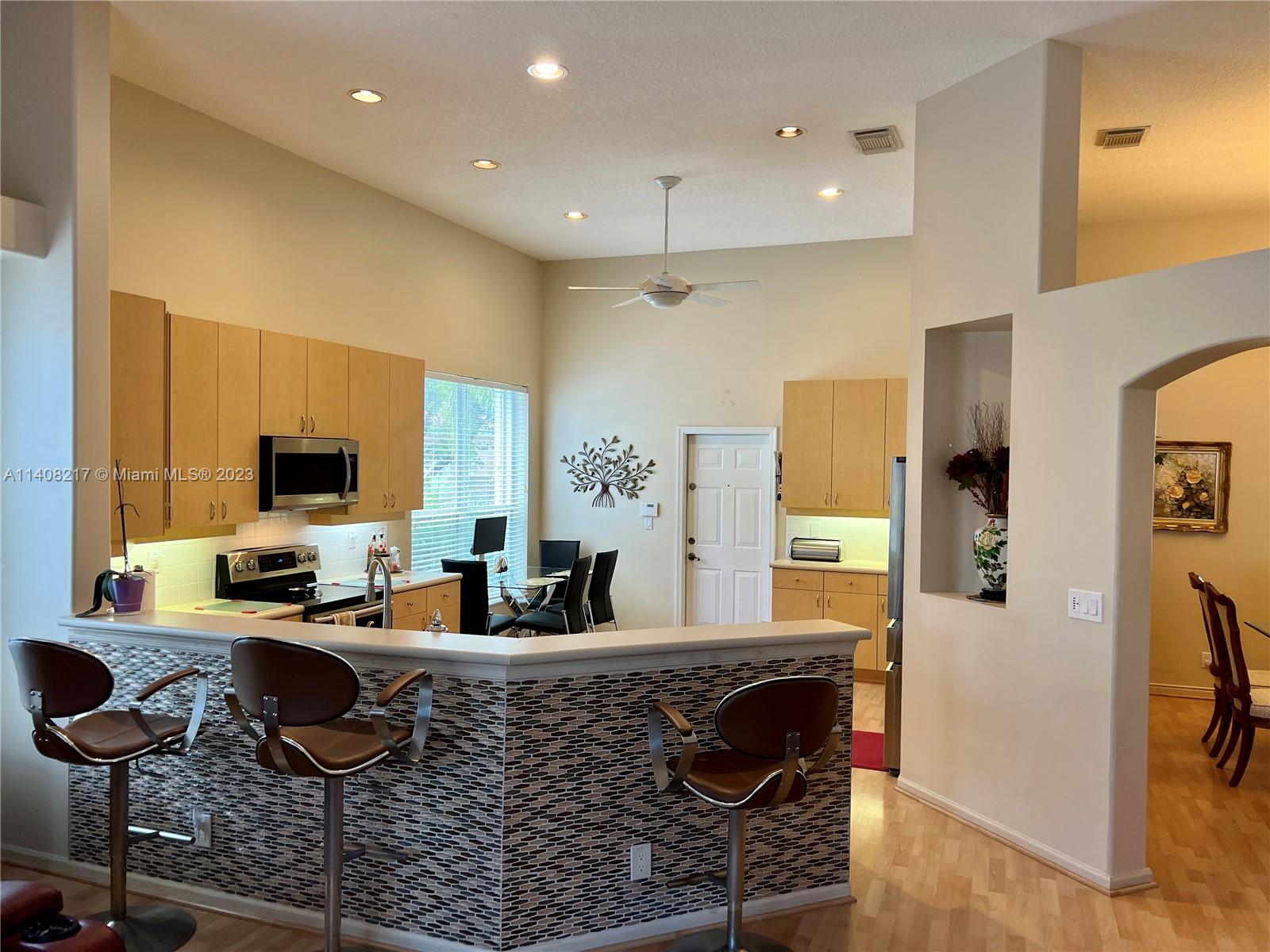 Oakridge Hollywood, FL 33312 - Photo 11 of 33 a living room with granite countertop couches a coffee table and a large window with wooden floor
