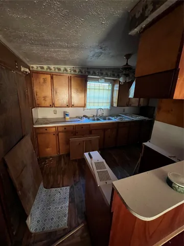 a kitchen with a sink a refrigerator and wooden cabinets