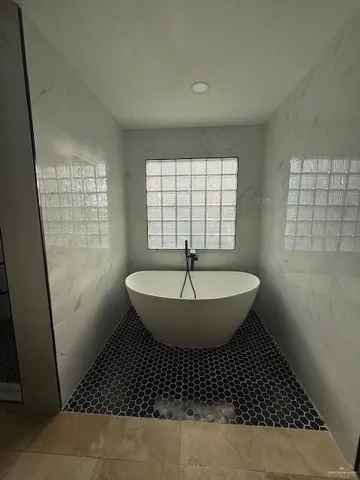 a bathroom with a sink a toilet a window and shower