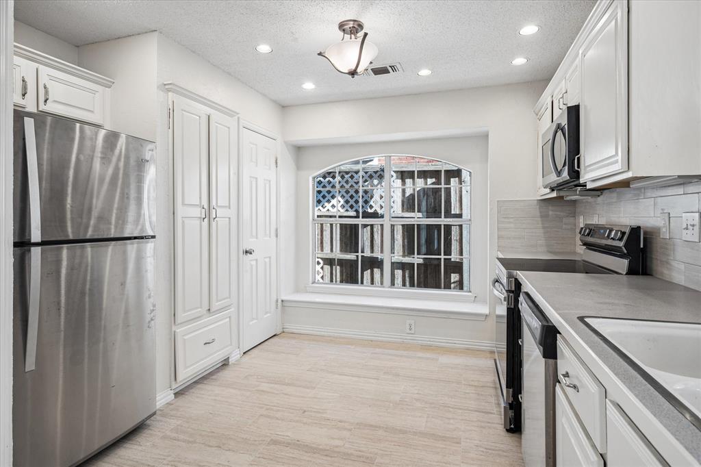 14592 Greenleaf Court Addison, TX 75001 - Photo 12 of 30 a view of kitchen with stainless steel appliances granite countertop a refrigerator and a sink