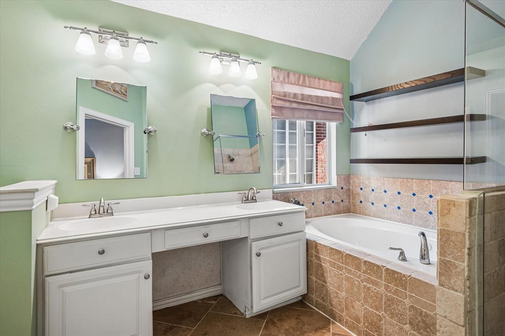14592 Greenleaf Court Addison, TX 75001 - Photo 15 of 30 a bathroom with a tub sink and mirror