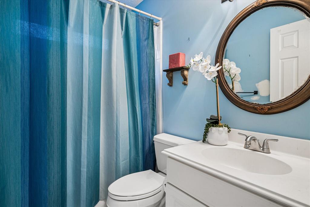 14592 Greenleaf Court Addison, TX 75001 - Photo 21 of 30 a bathroom with a sink a toilet and mirror