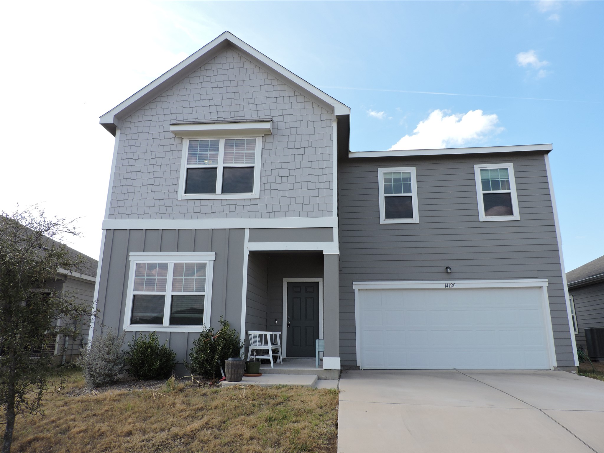 View of front of property with an attached garage, concrete driveway, and board and batten siding