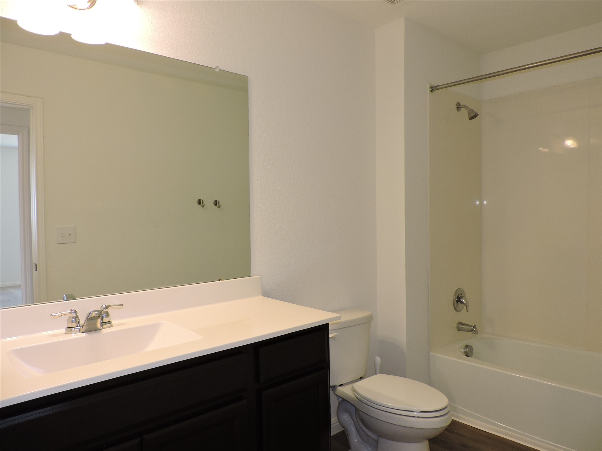 14120 Jeannette Rankin Rd Manor Manor, TX 78653 - Photo 17 of 25 Full bathroom featuring washtub / shower combination, vanity, and dark wood-type flooring
