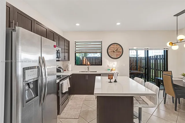 a kitchen with stainless steel appliances a table chairs and a refrigerator