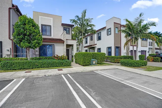 a front view of multiple houses with yard