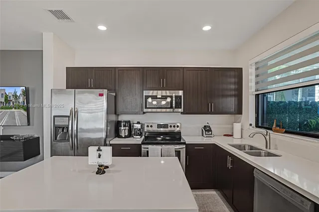 a kitchen with a refrigerator a sink a stove a microwave and cabinets